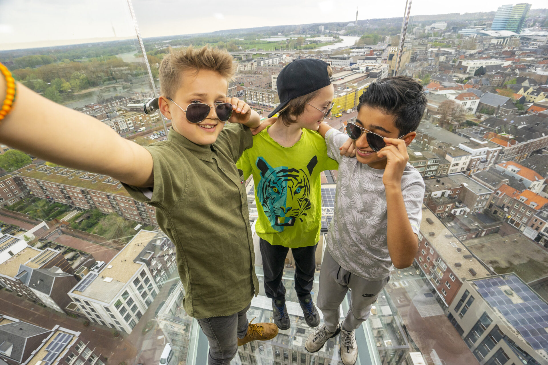 Drie kinderen op het glazen balkon van de Eusebius kerk in Arnhem.