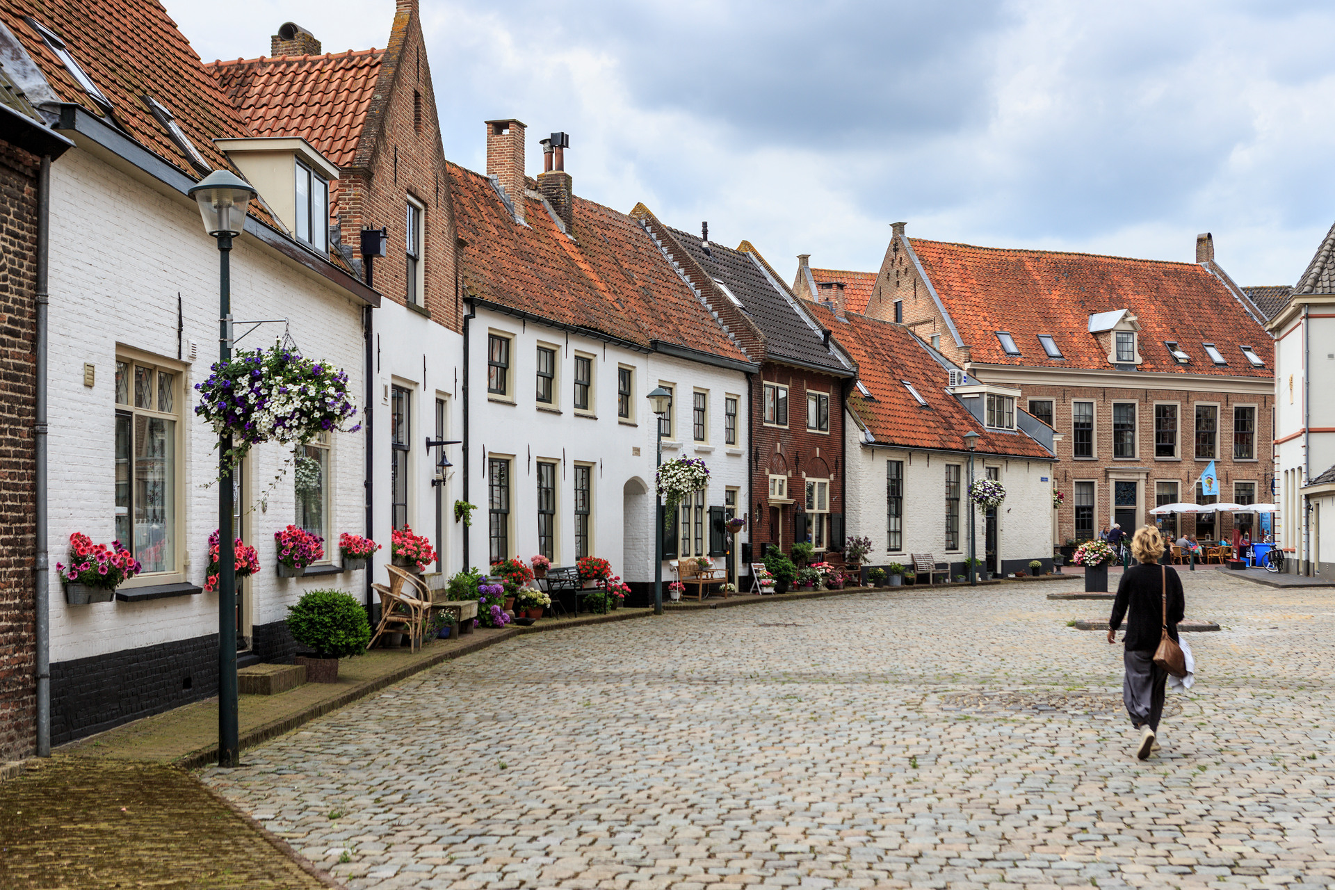 Frau geht an malerischen Häusern in der historischen Hansestadt Hattem vorbei