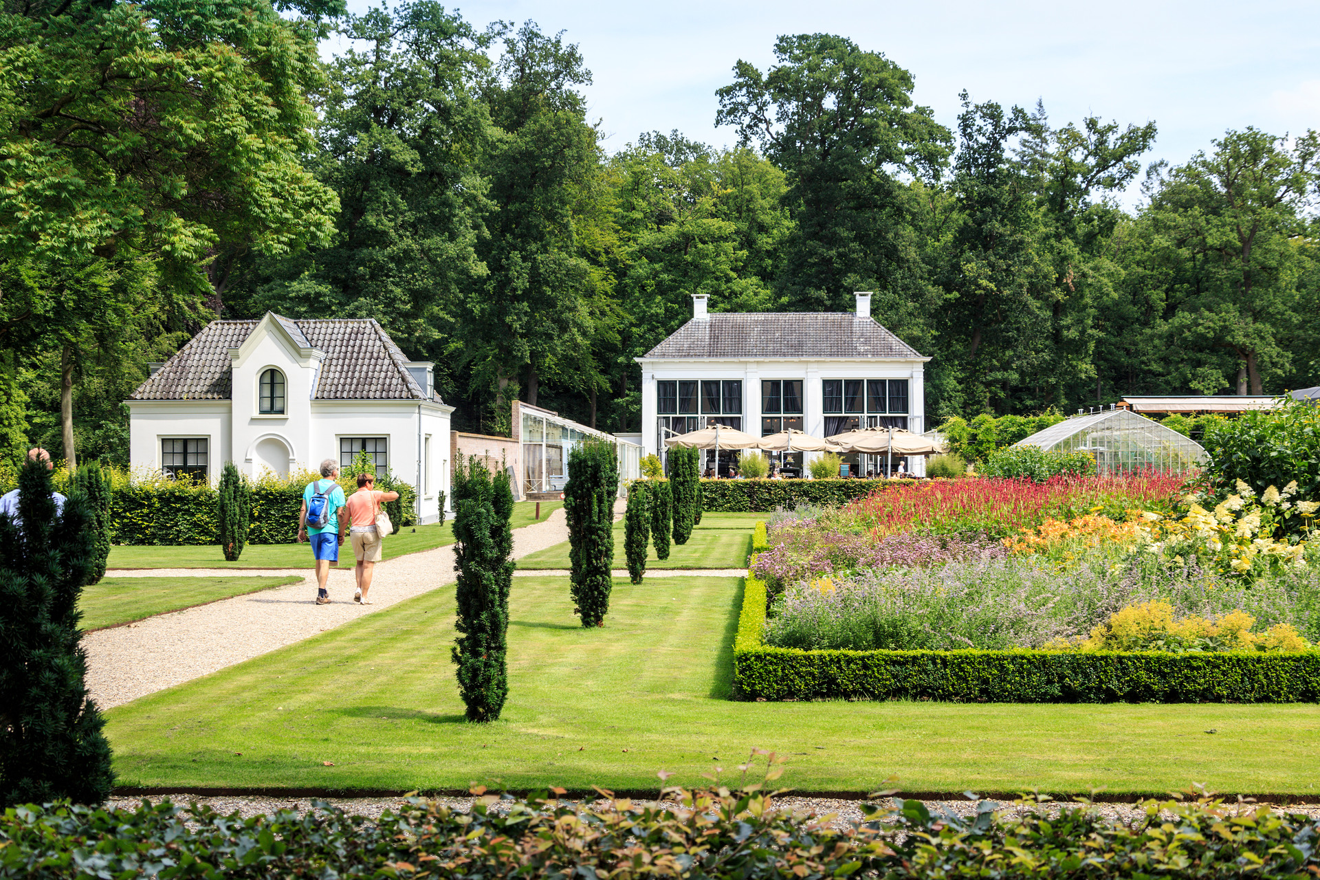 Mensen lopen in de tuinen van Landgoed Staverden naar de Brasserie