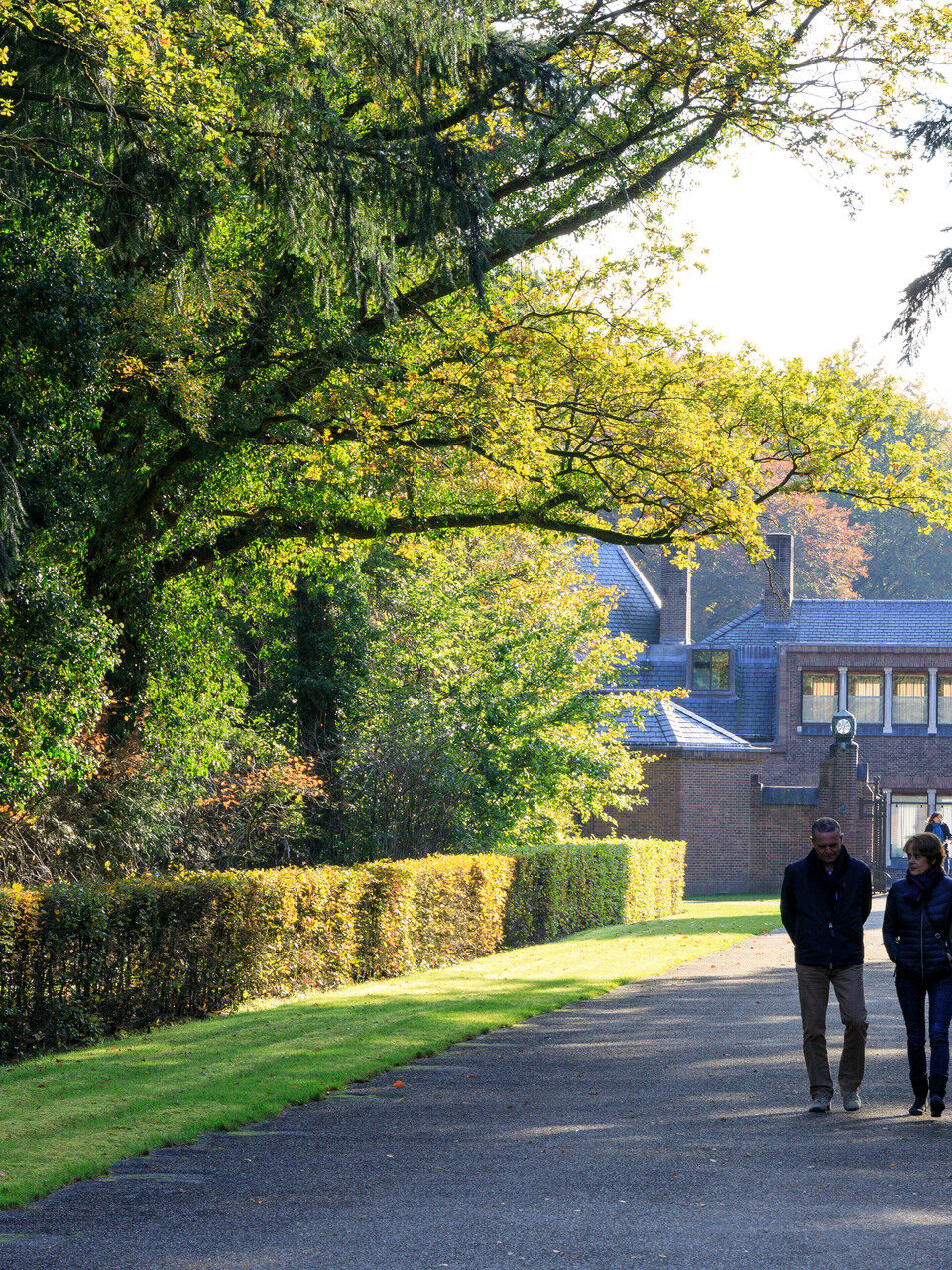 Man en vrouw wandelen bij Jachthuis Sint Hubertus