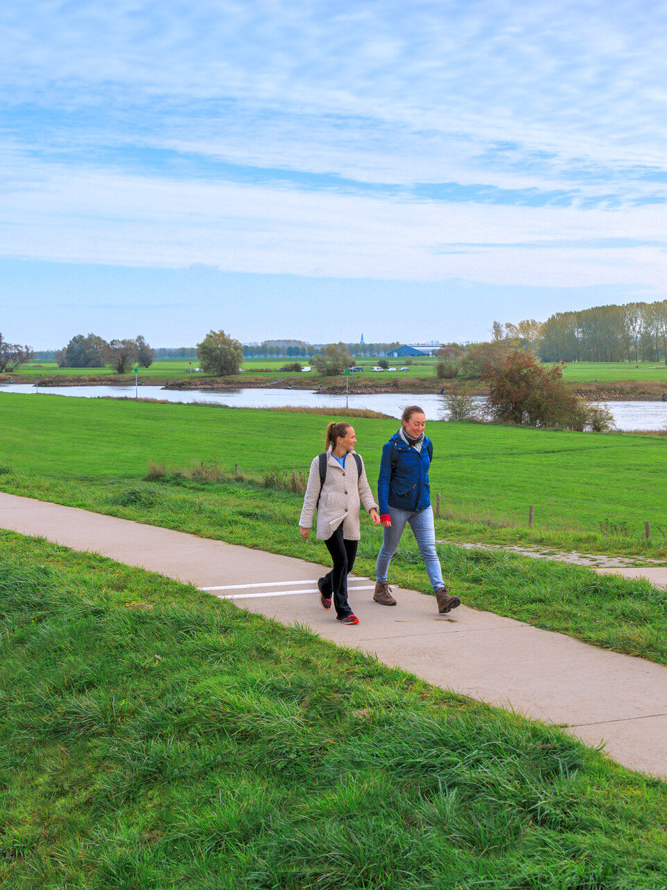 Two people walk on a path in Brummen municipality.