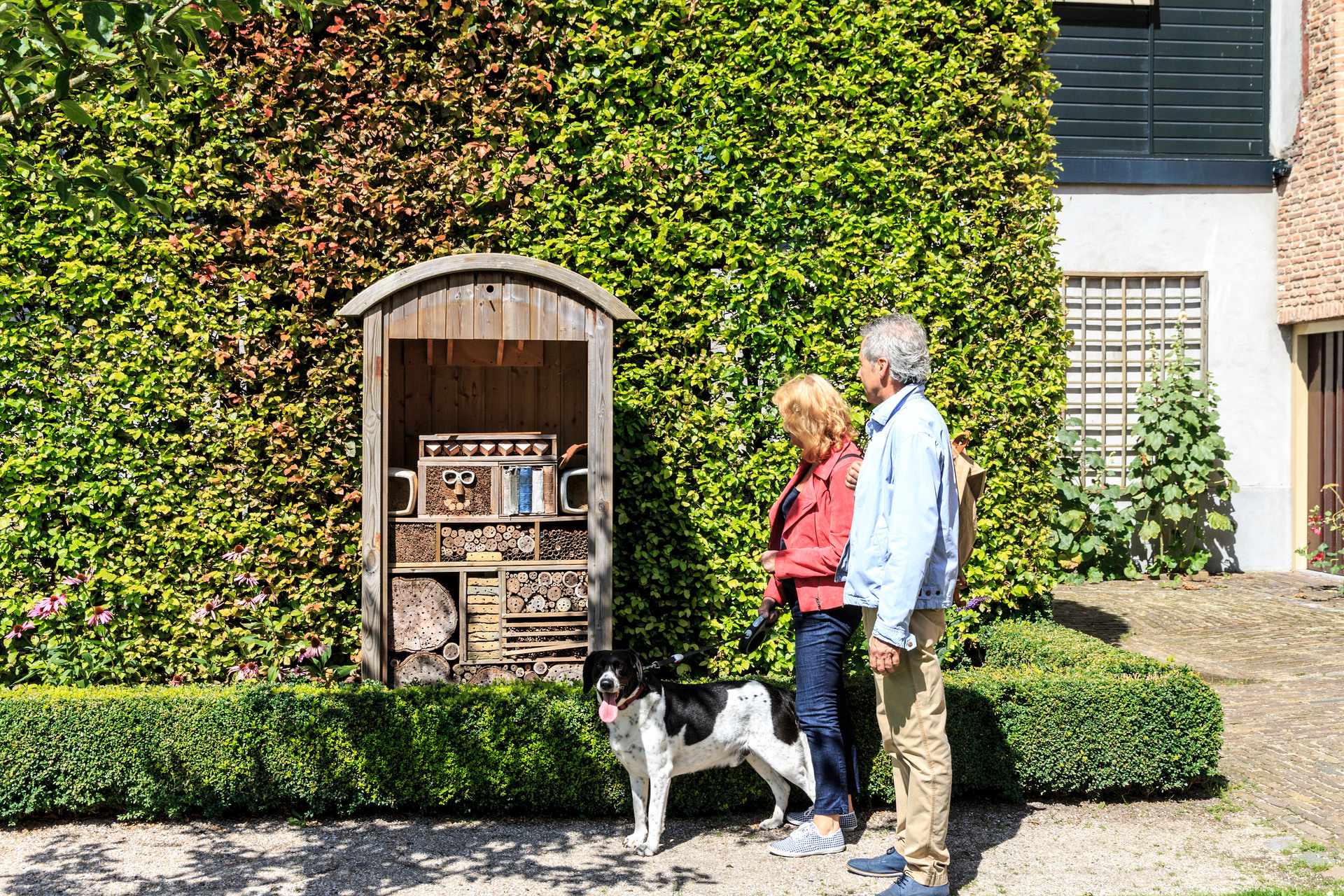 Twee mensen lopen door stad Elburg, op de achtergrond zie je museum Elburg