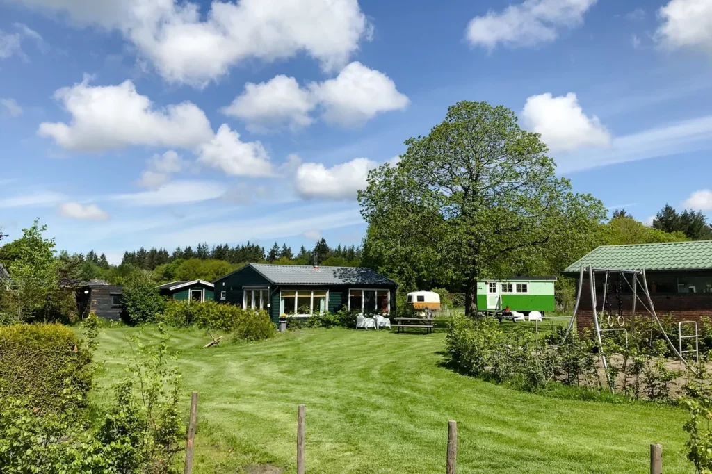 Overzicht foto van camping met pippo wagen, caravan, huisjes en klimtoestellen