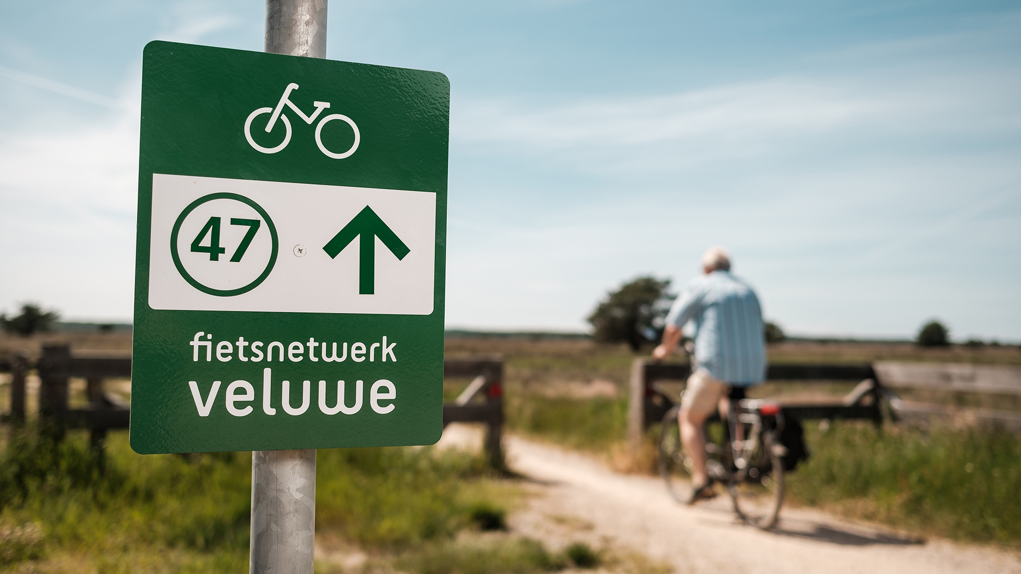 fietsknooppuntbordje met een man die langsfietst