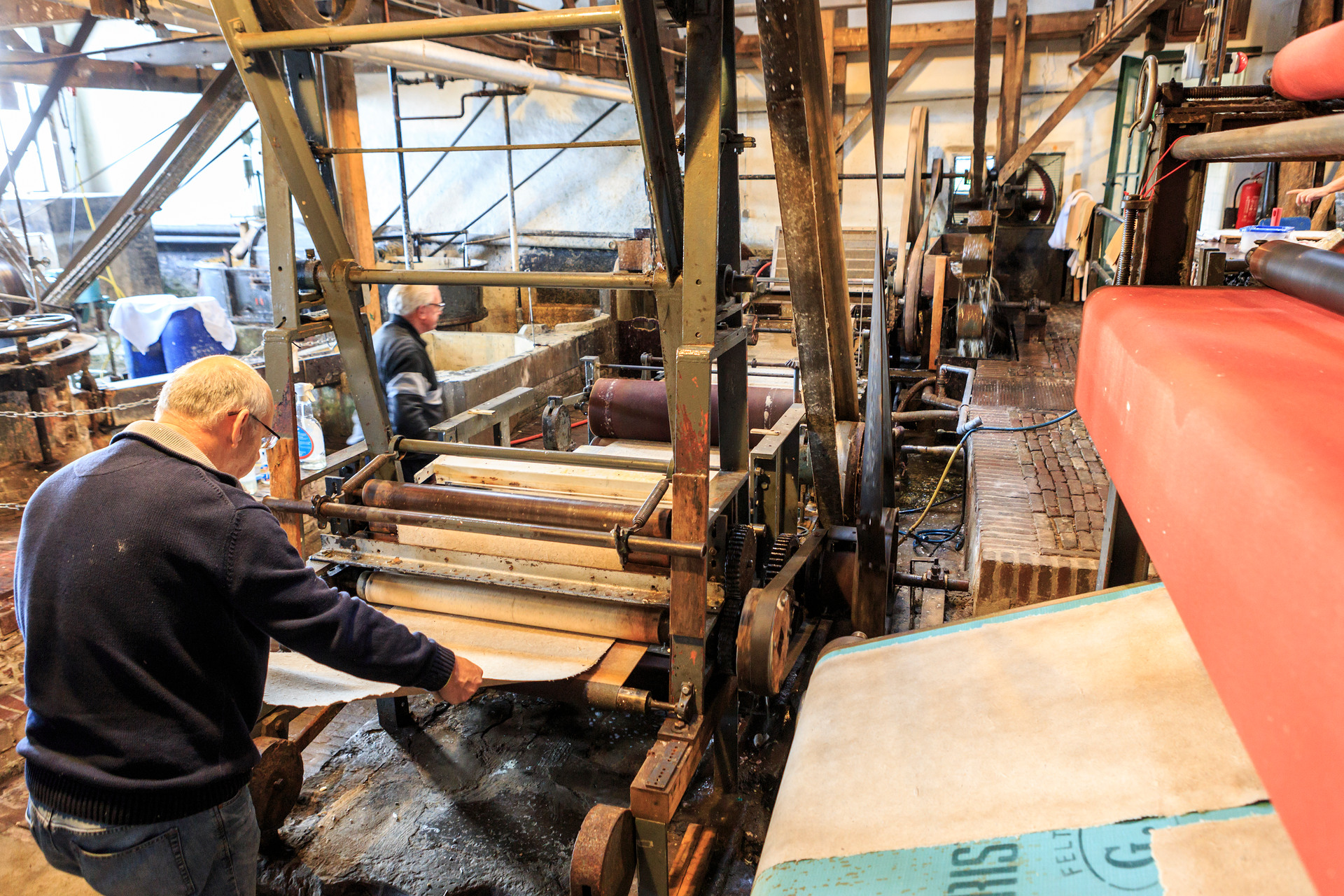 Man maakt papier in molen in houten machine