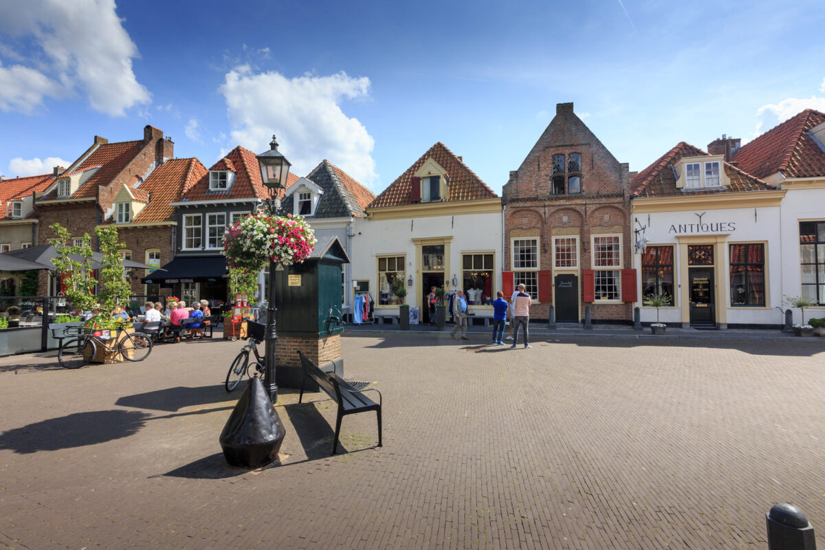 Winkelstraat in Harderwijk op een zonnige dag met terras en blauwe lucht met witte wolken