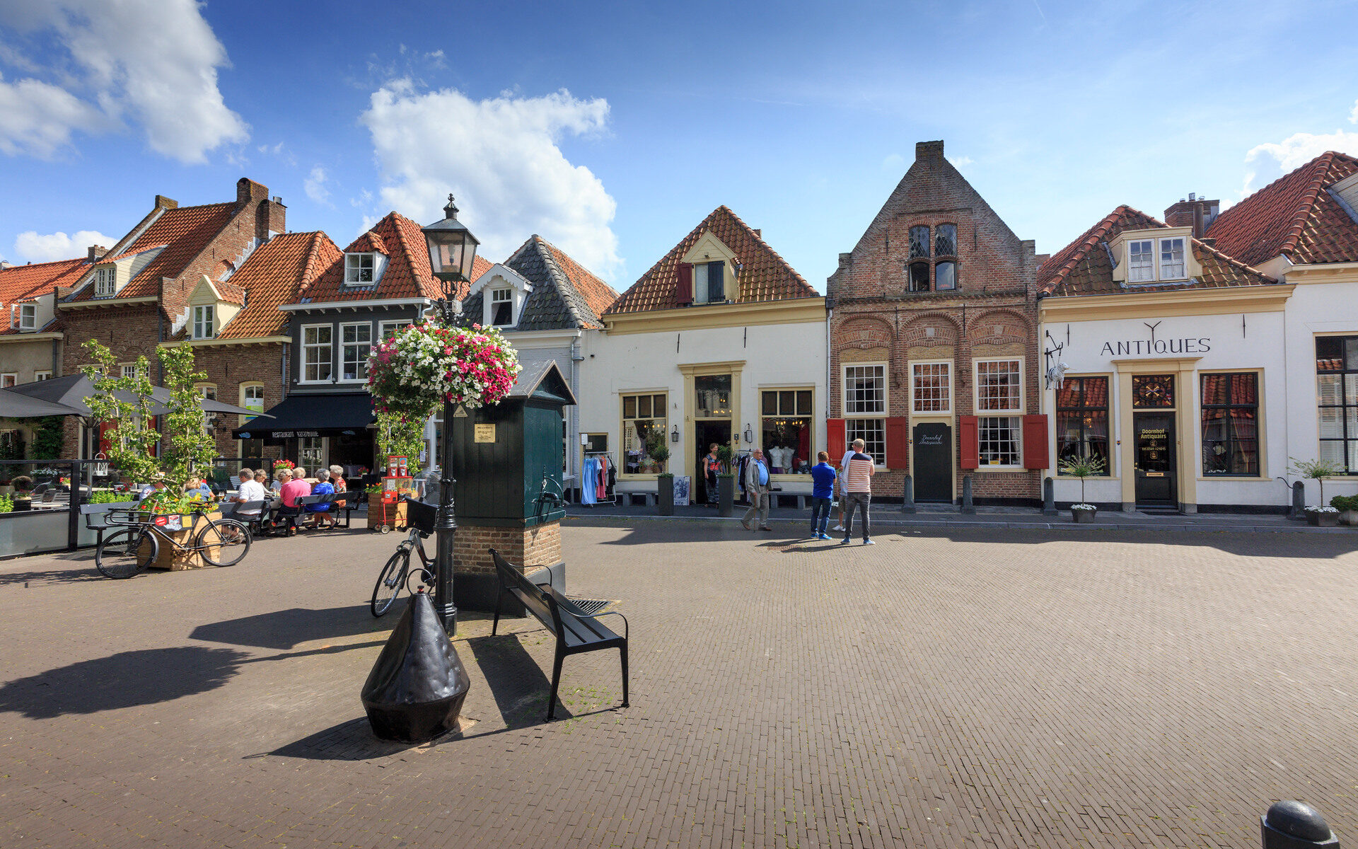 Winkelstraat in Harderwijk op een zonnige dag met terras en blauwe lucht met witte wolken