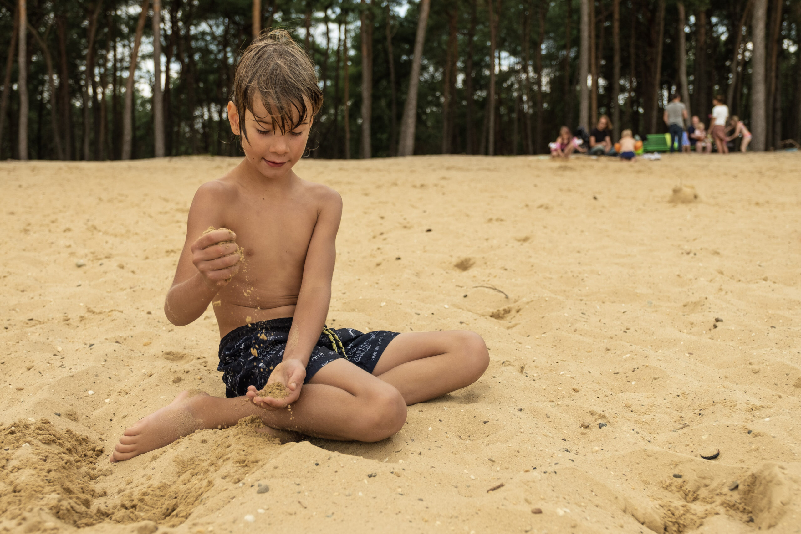 Kind zit in zijn zwembroek aan het Heerderstrand