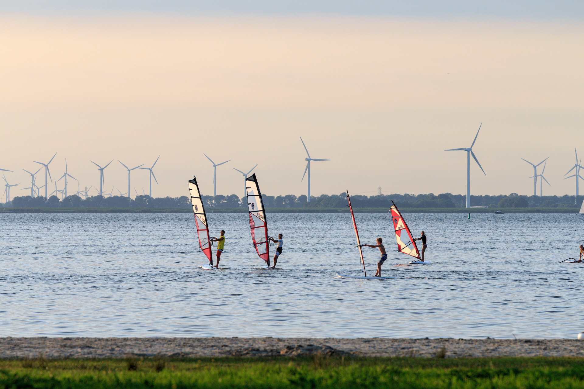 Een groep windsurfers op het water van Strand Nulde in de gemeente Putten op de Veluwe