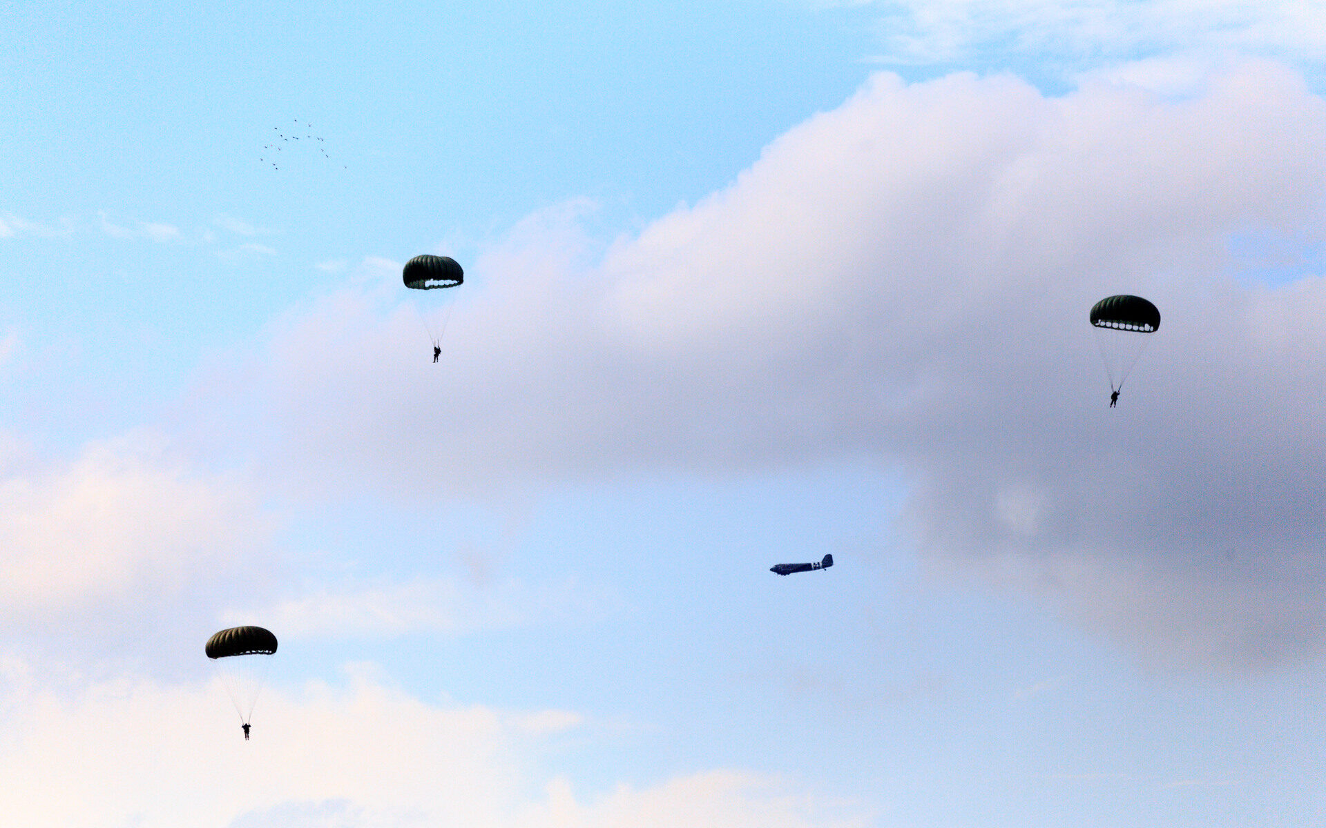 Parachutisten blauwe lucht, wolken Wo2 vliegtuig.