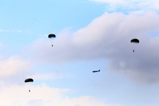 Parachutisten blauwe lucht, wolken Wo2 vliegtuig.