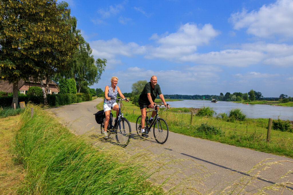 Een man en een vrouw op de fiets langs de IJssel.