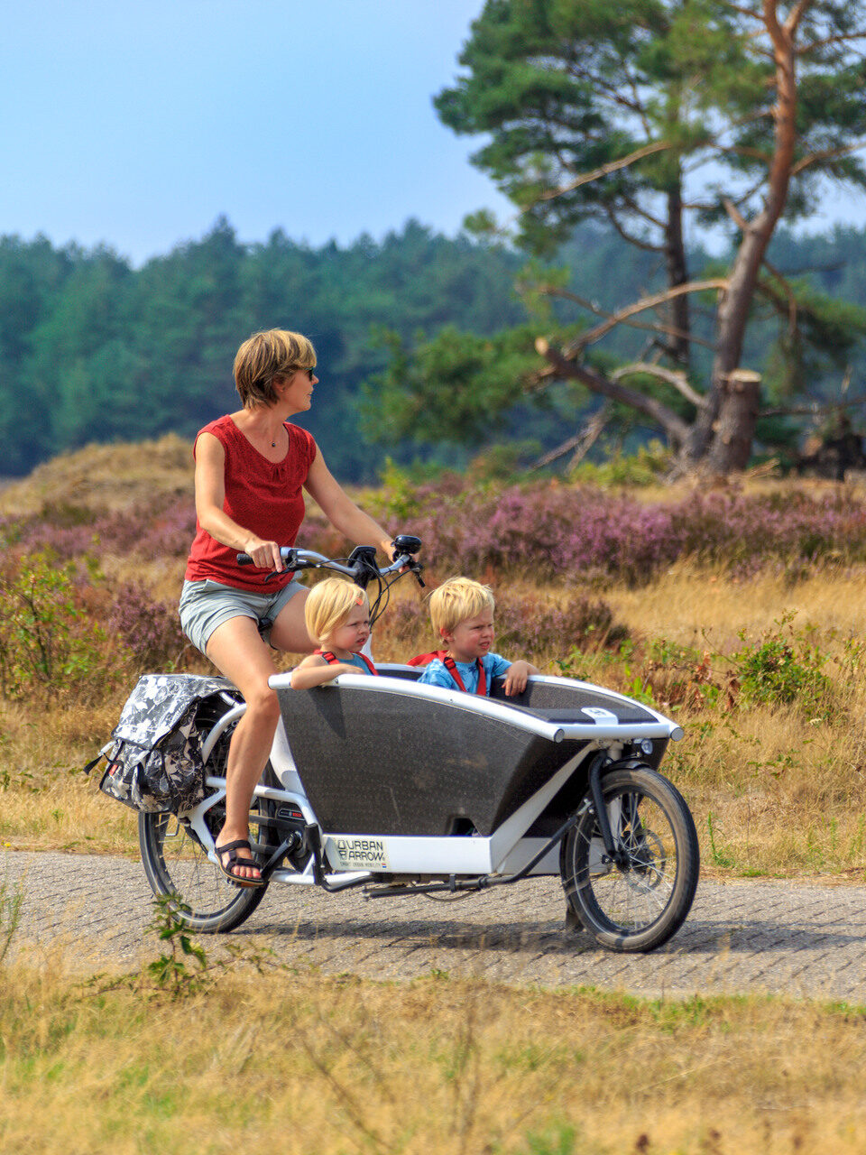 Moeder en twee kinderen genieten van een fietstochtje.