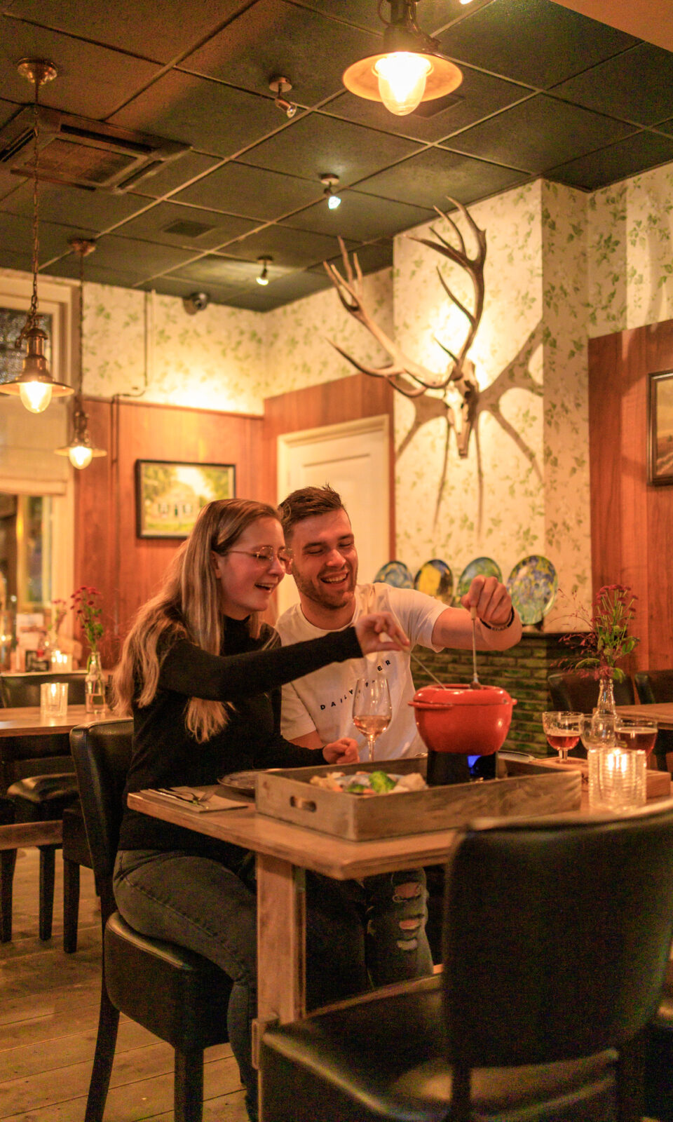 A couple cozy up at a table in restaurant the Waldhoorn in Otterlo.