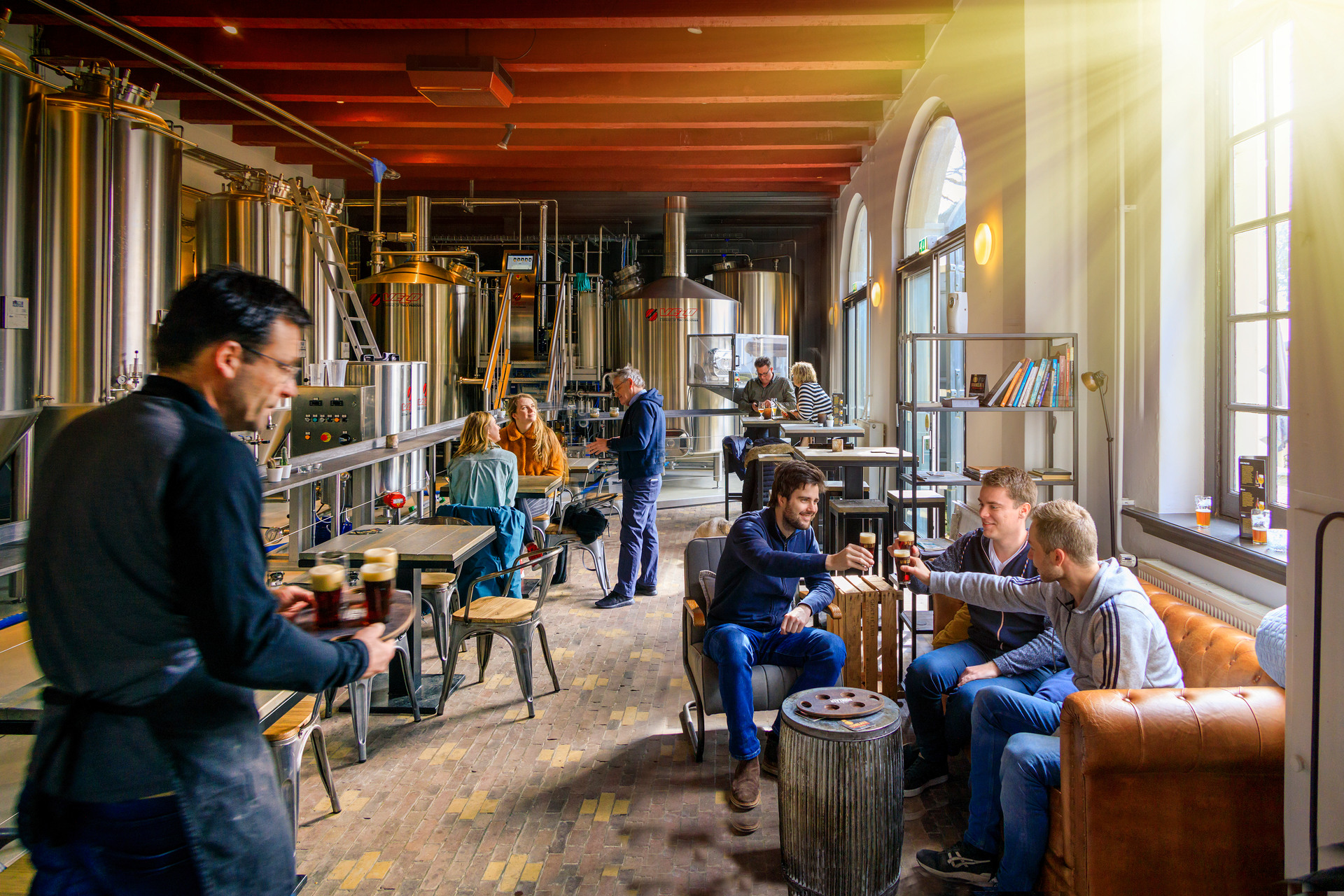 Een groep mensen genietend van een bierproeverij in Bierbrouwerij De Uddelaer, Landgoed Staverden