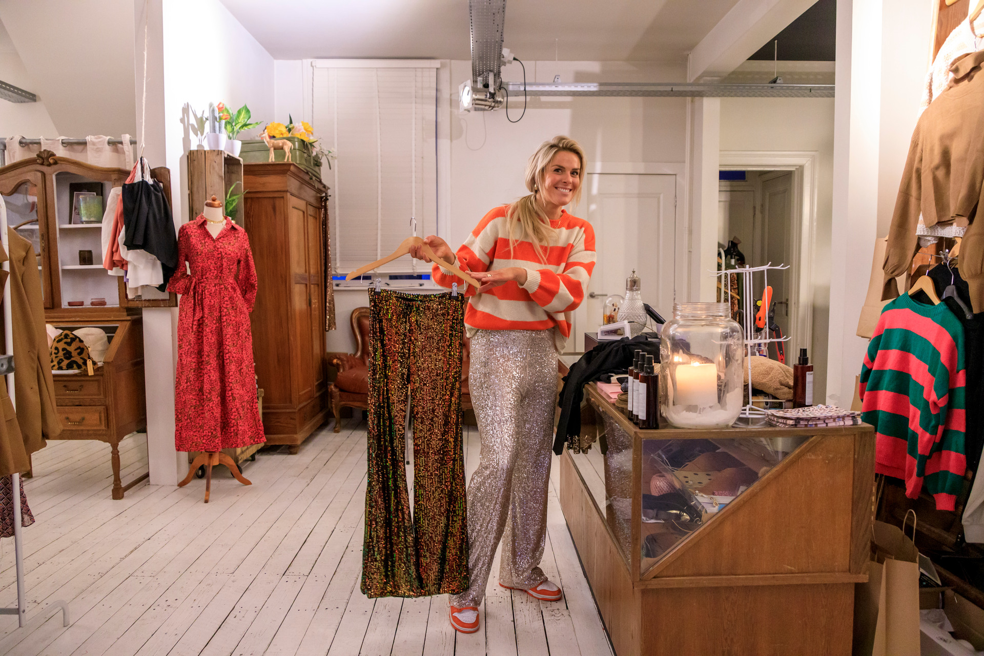 A sales assistant shows off a pair of trousers at a clothing shop in Apeldoorn