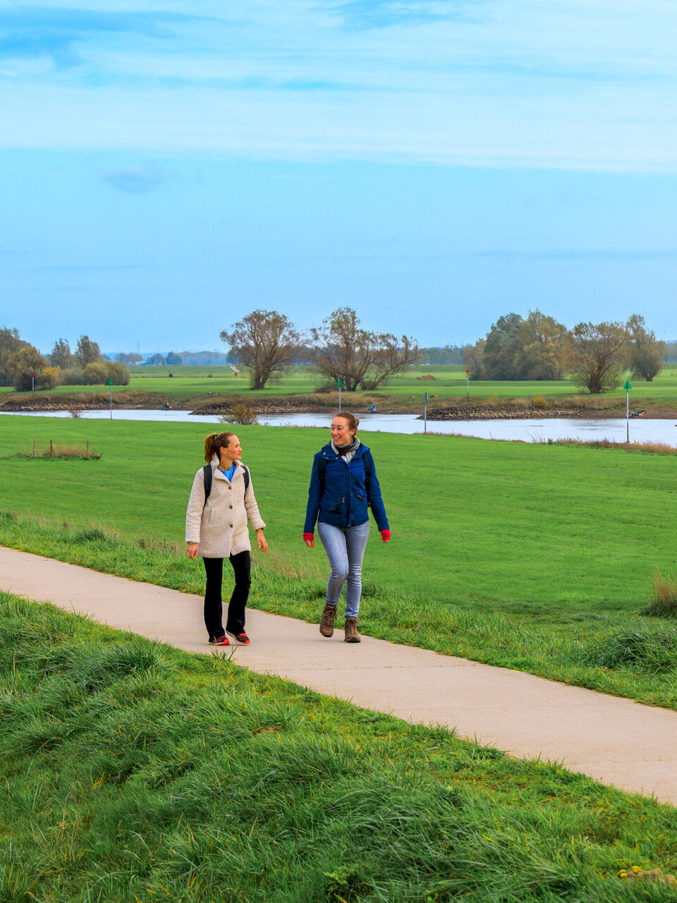 Twee vrouwen die op de Brummense Bandijk lopen