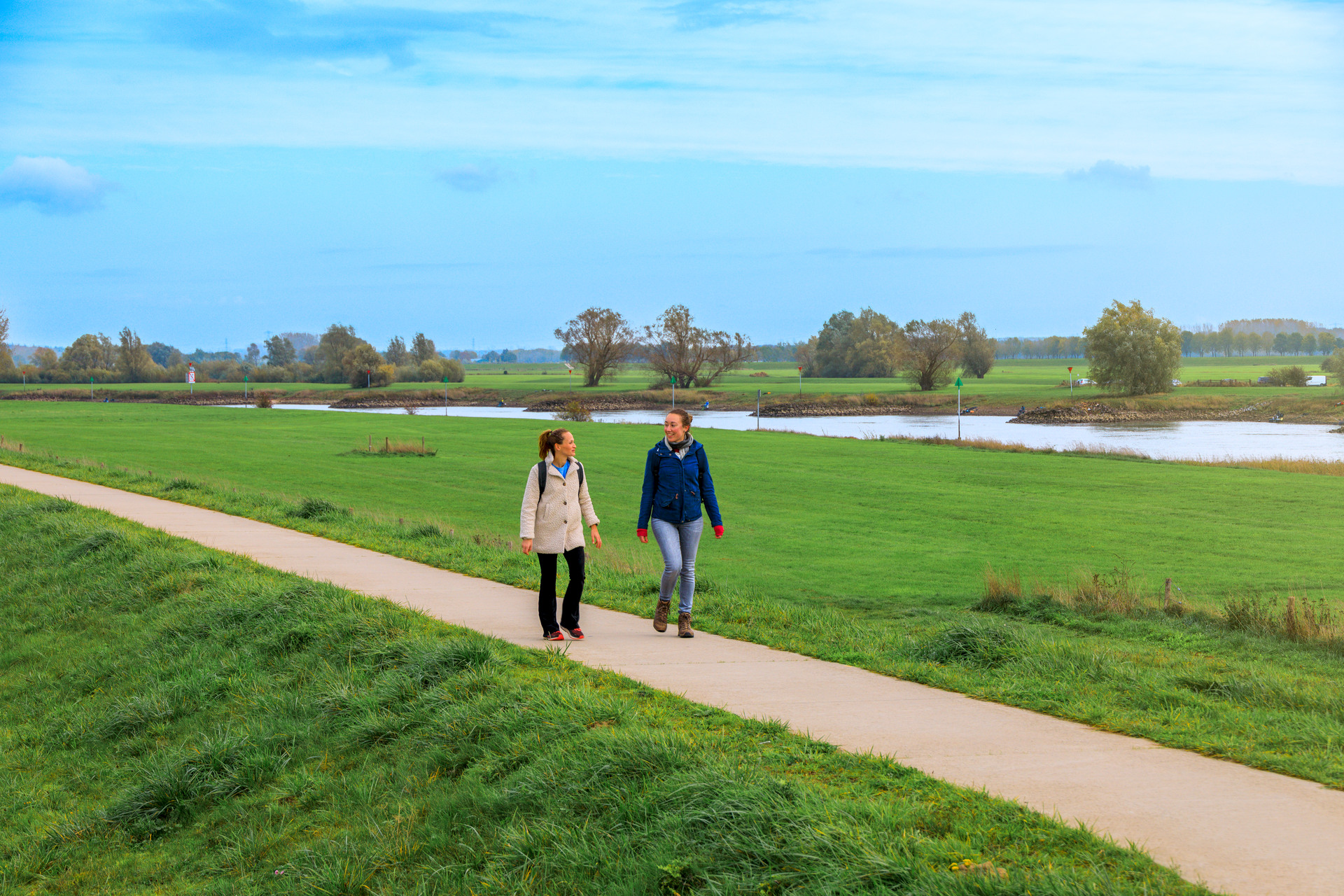 Twee vrouwen die op de Brummense Bandijk lopen