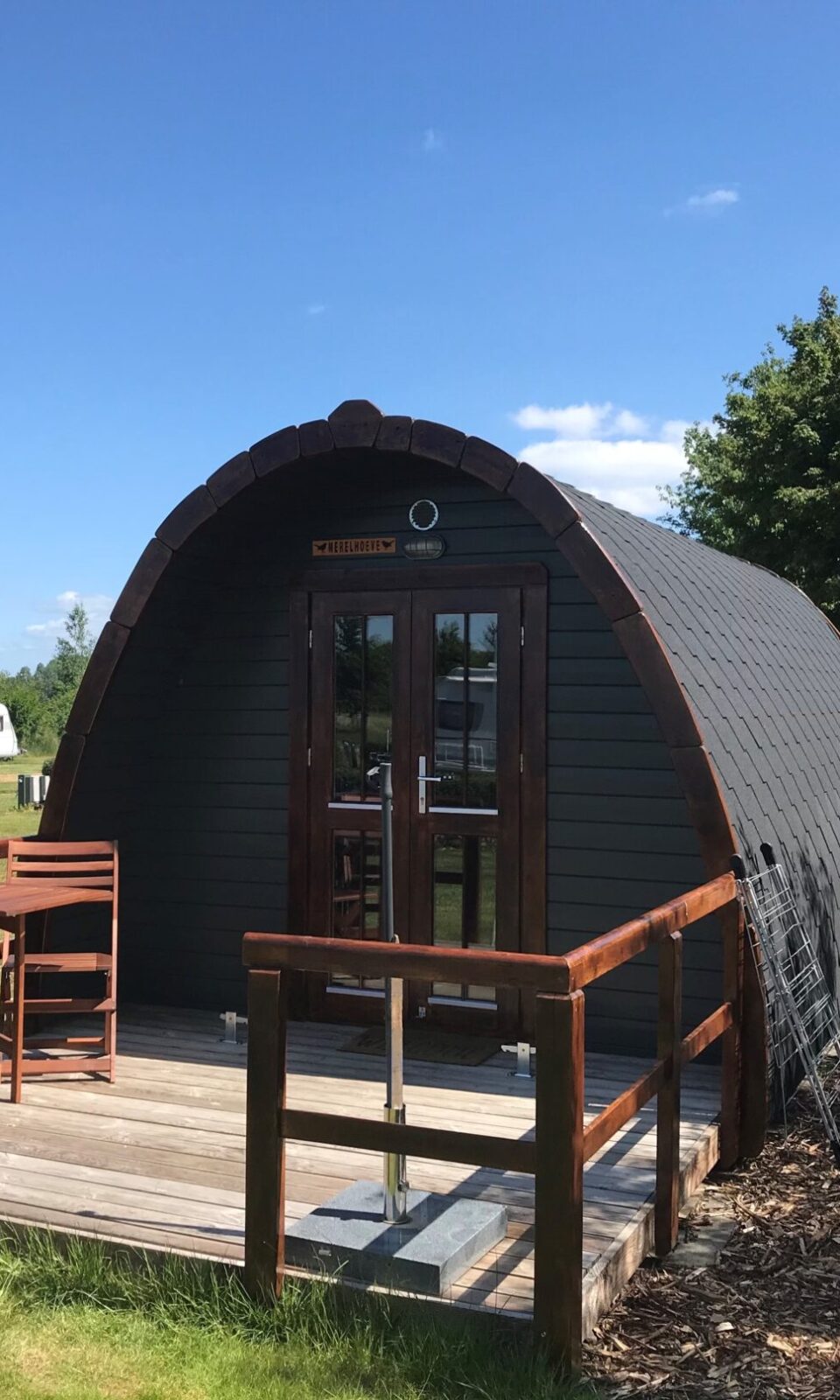 A camping pod with a deck and a table