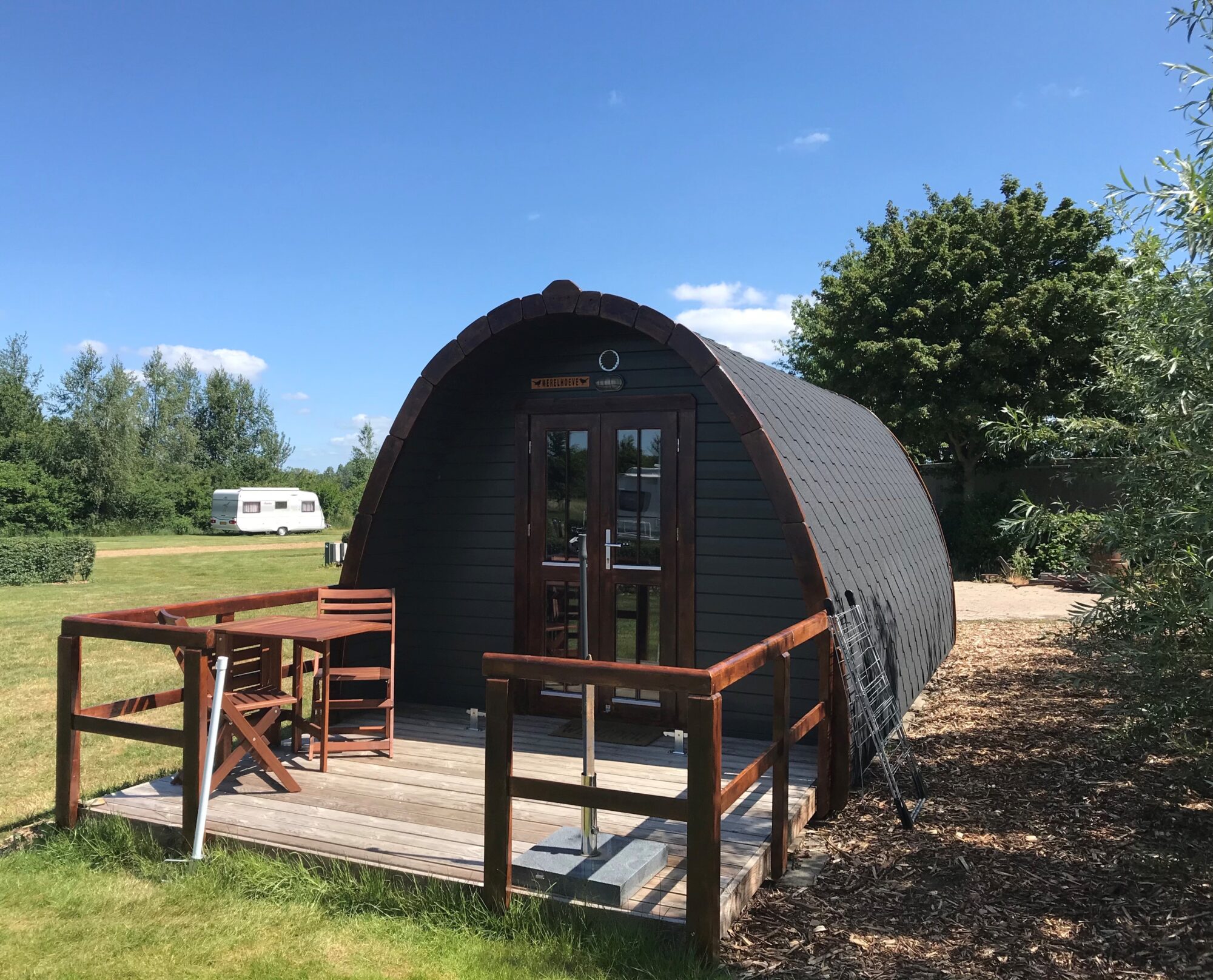 Een kampeer pod met een dek en een tafel