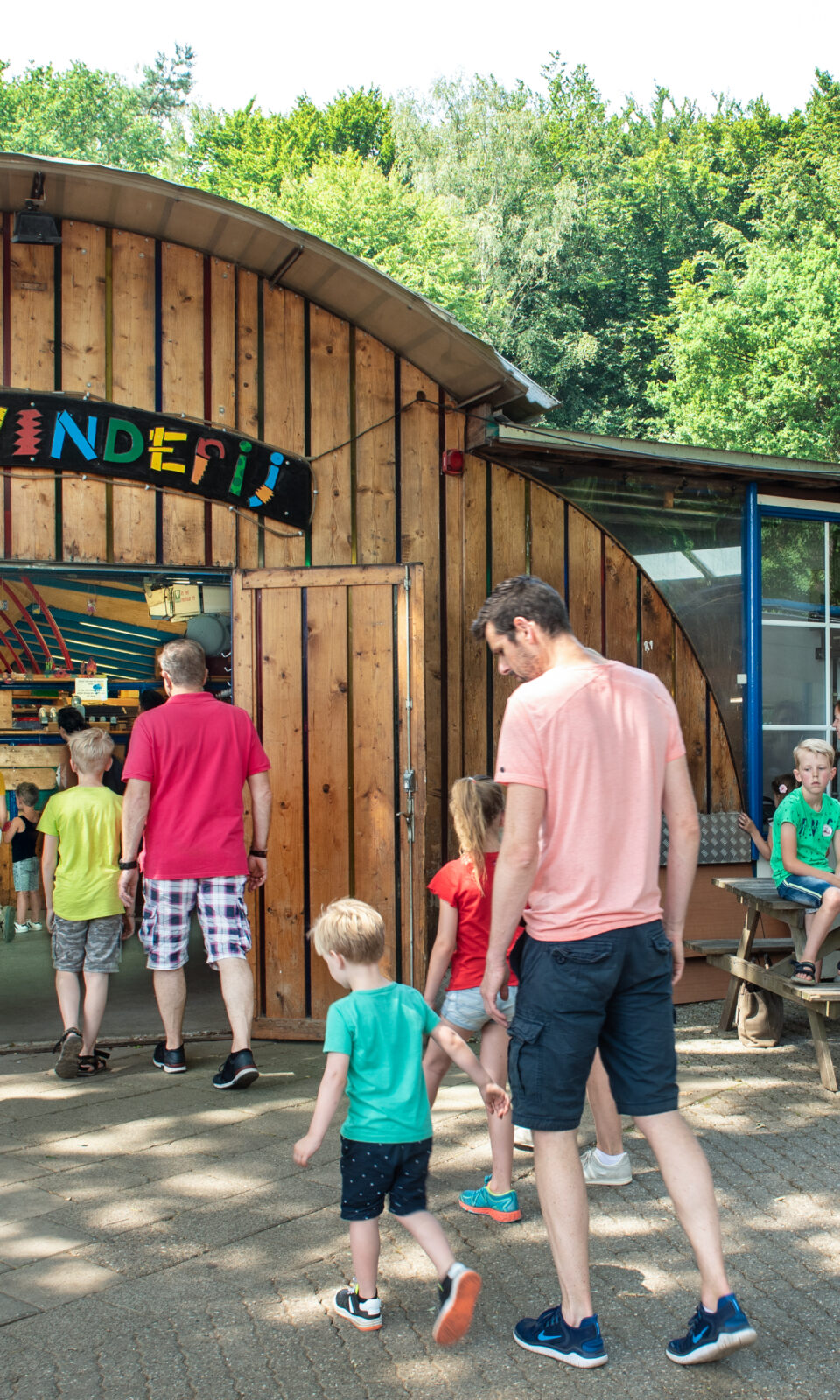 Man met jonge kinderen voor ingang van de Spelerij - Uitvinderij