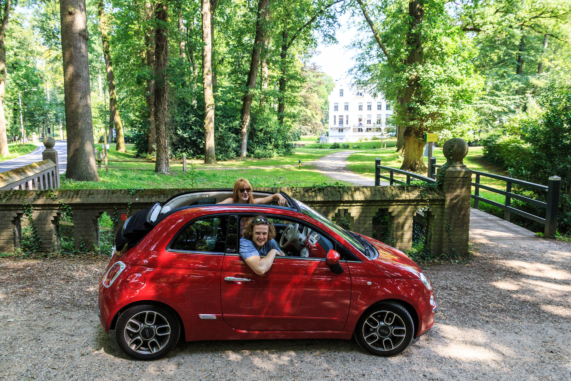 Menschen im Auto mit dem Gut Staverden im Hintergrund