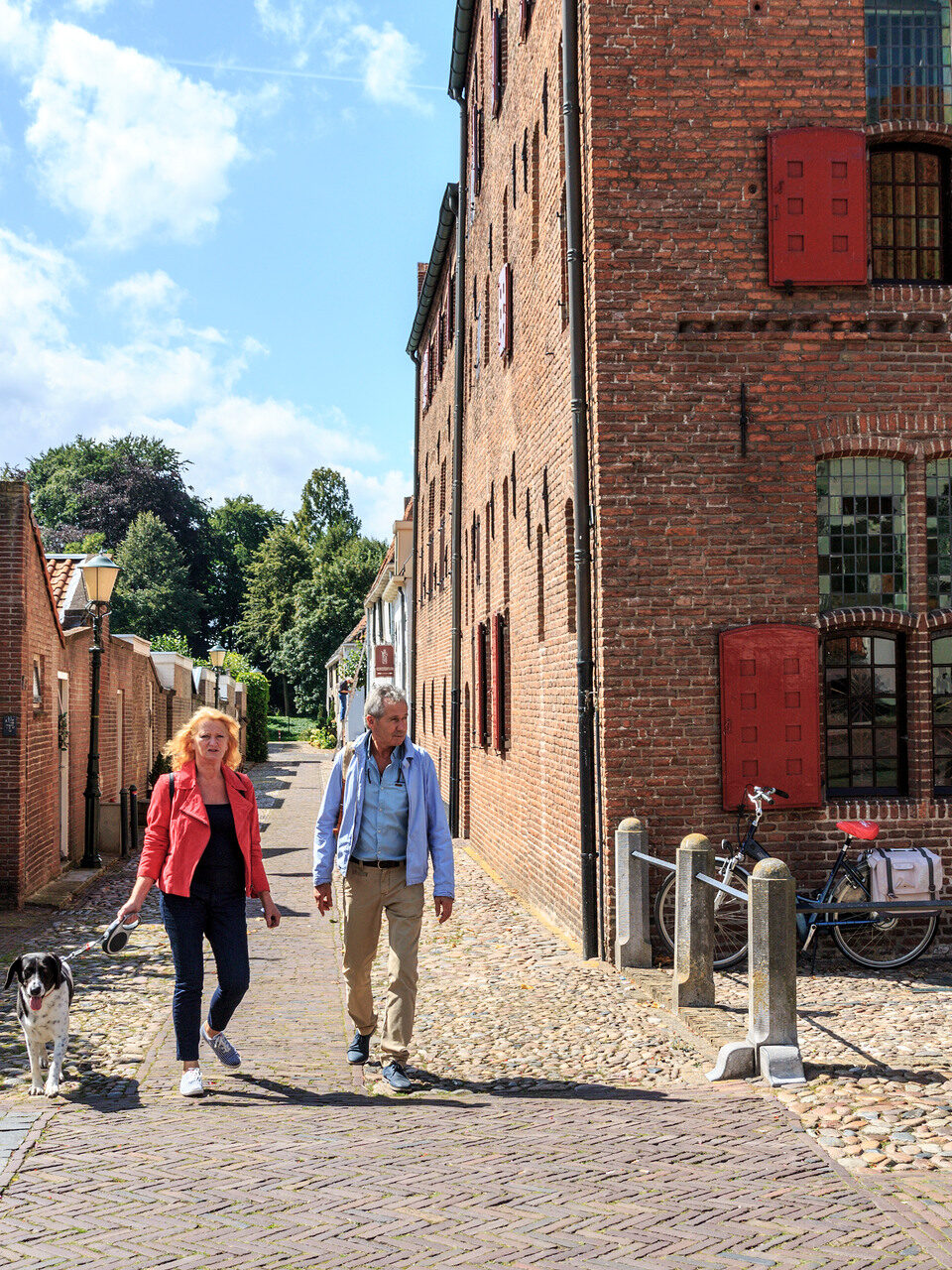 Man en vrouw wandelen lang Museum Elburg