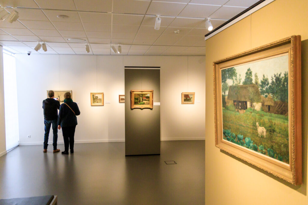 Personen kijken naar kunst in het Noord-Veluws Kunstmuseum.