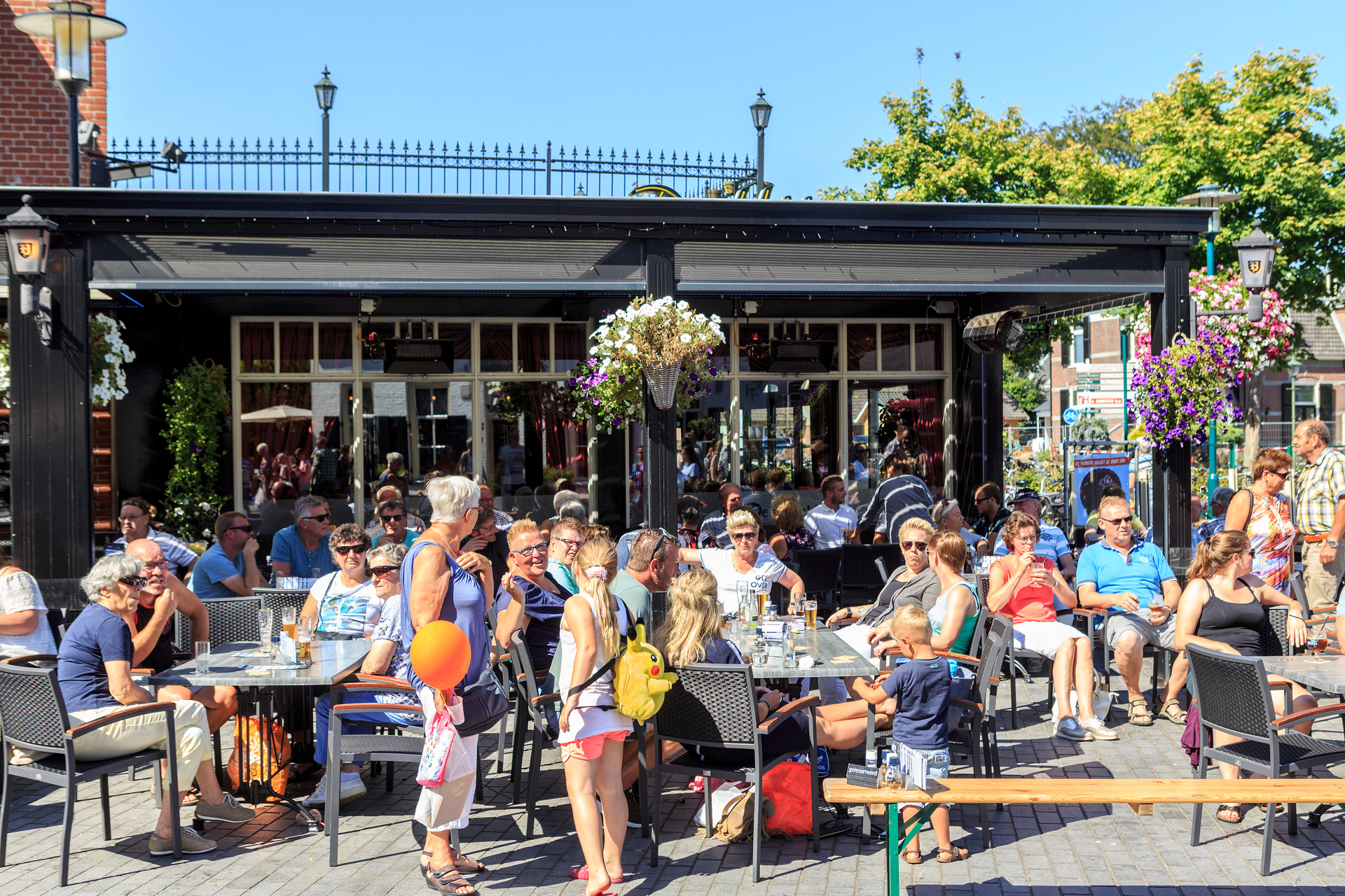 Mensen zitten zomers gekleed op een terrasje tijdens de Oud-Veluwse markt in Barneveld