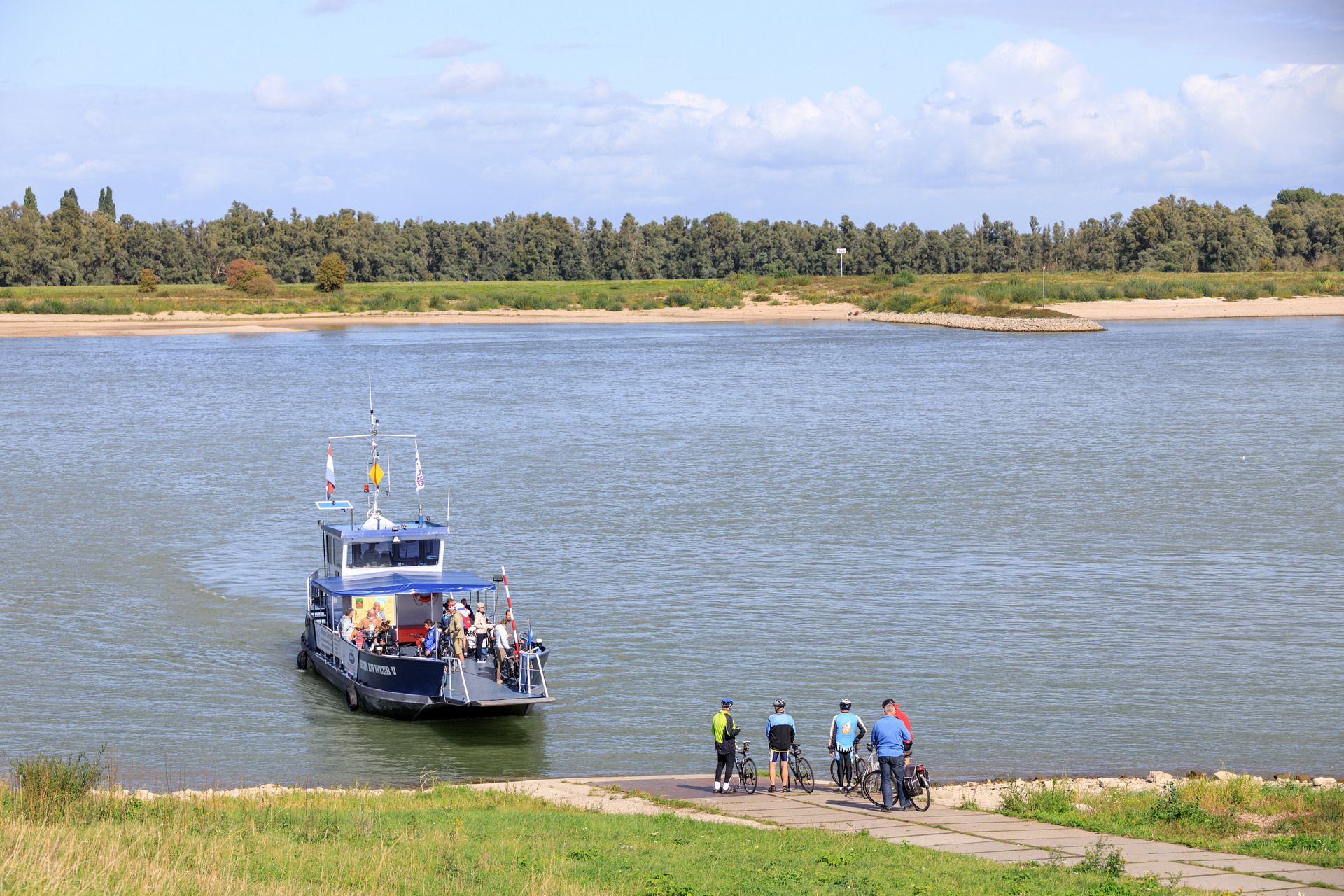 Veerpont zet fietsers over naar de andere kant van de rivier