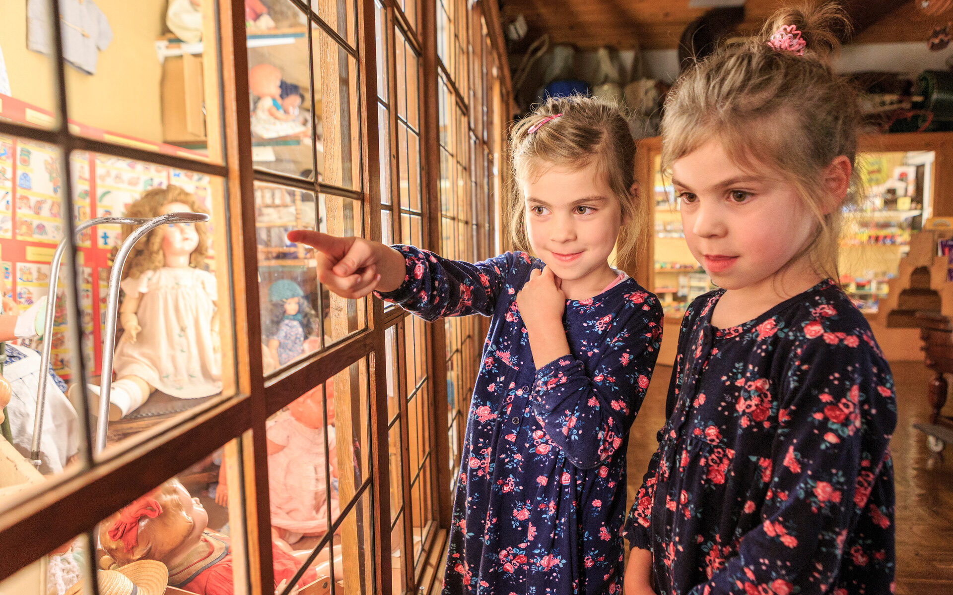 Twee meisjes bekijken poppen in een speelgoedmuseum