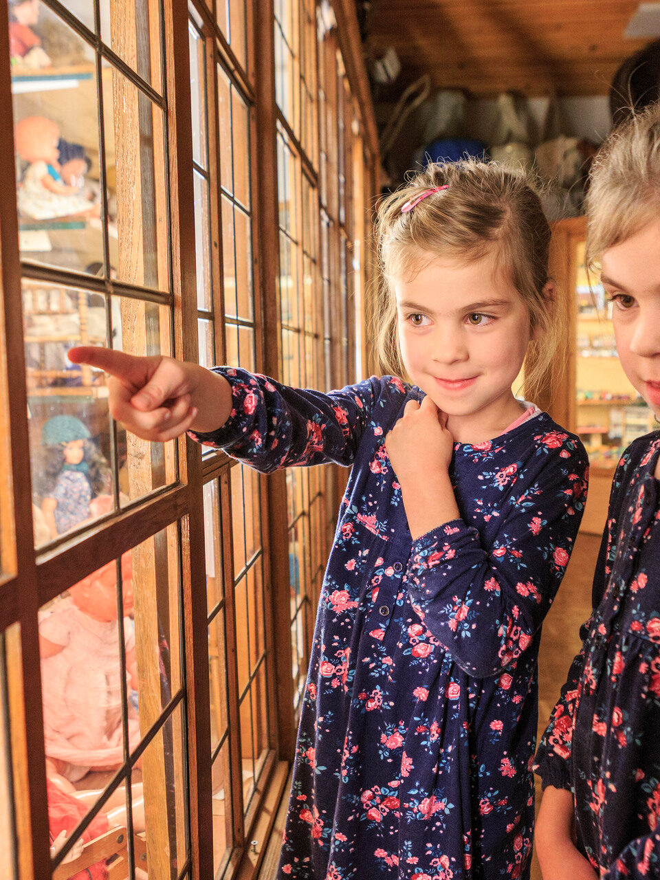 Twee meisjes bekijken poppen in een speelgoedmuseum