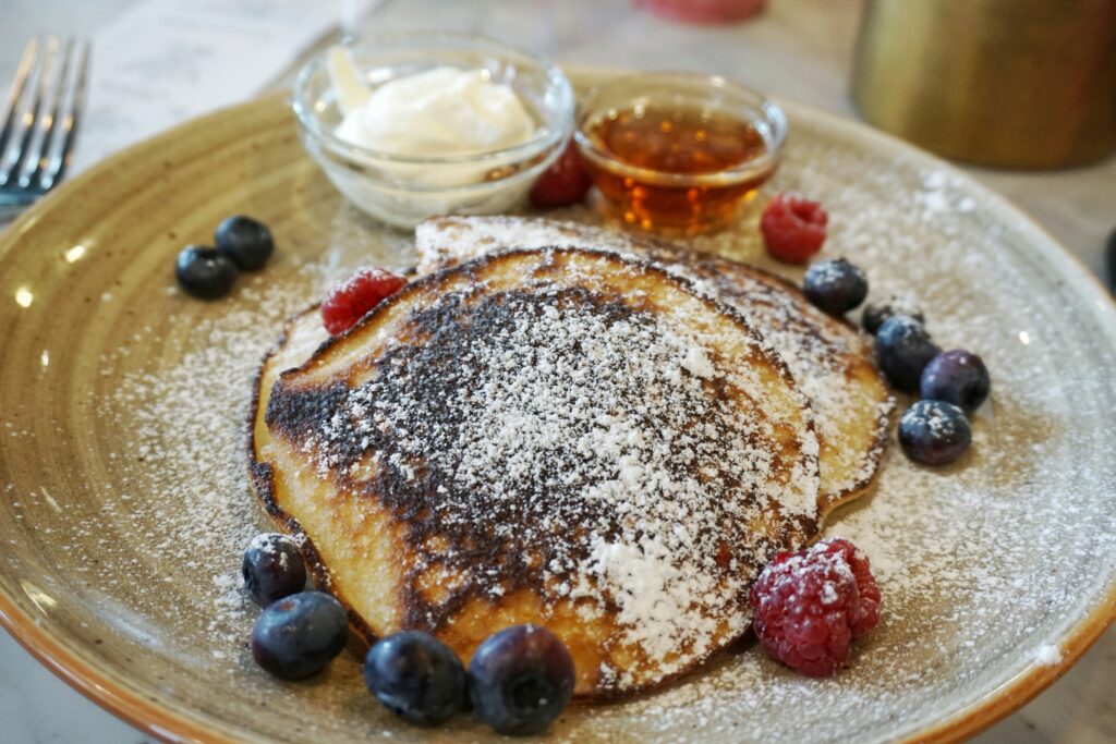 Bord met pannenkoeken en toppings.