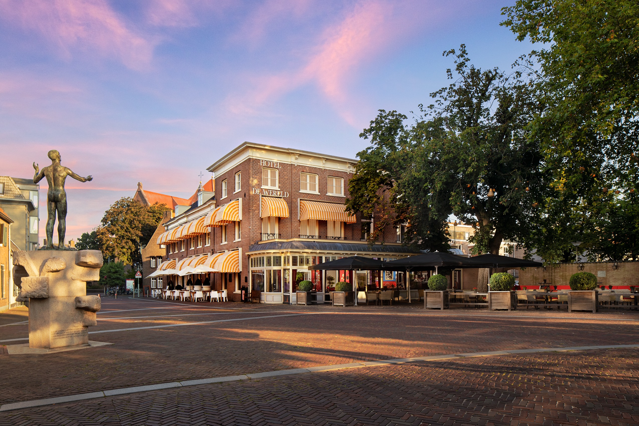 De buitenkant van Hotel de Wereld in Wageningen in de ondergaande zon