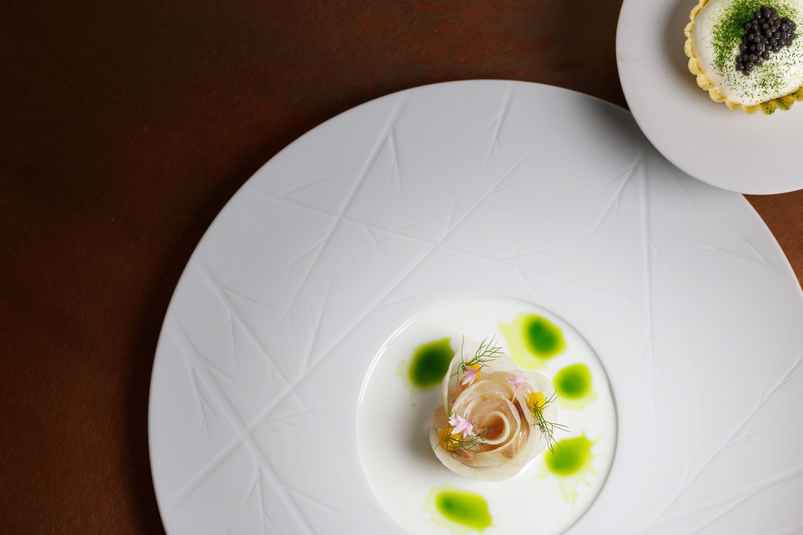 Twee witte borden met opgemaakte gerechtjes in restaurant Cèpes in Hotel de Sterrenberg in Otterlo