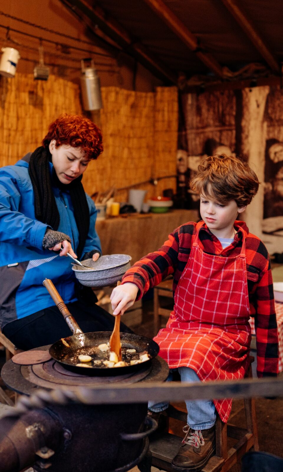 2 personen koken samen op de jaarmarkt in de winter in het openluchtmuseum.
