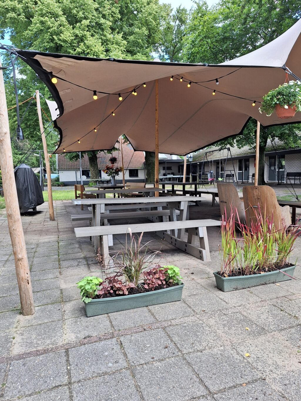 Overdekt terras met picknickbanken bij groepsaccommodatie De Beukhof in Putten